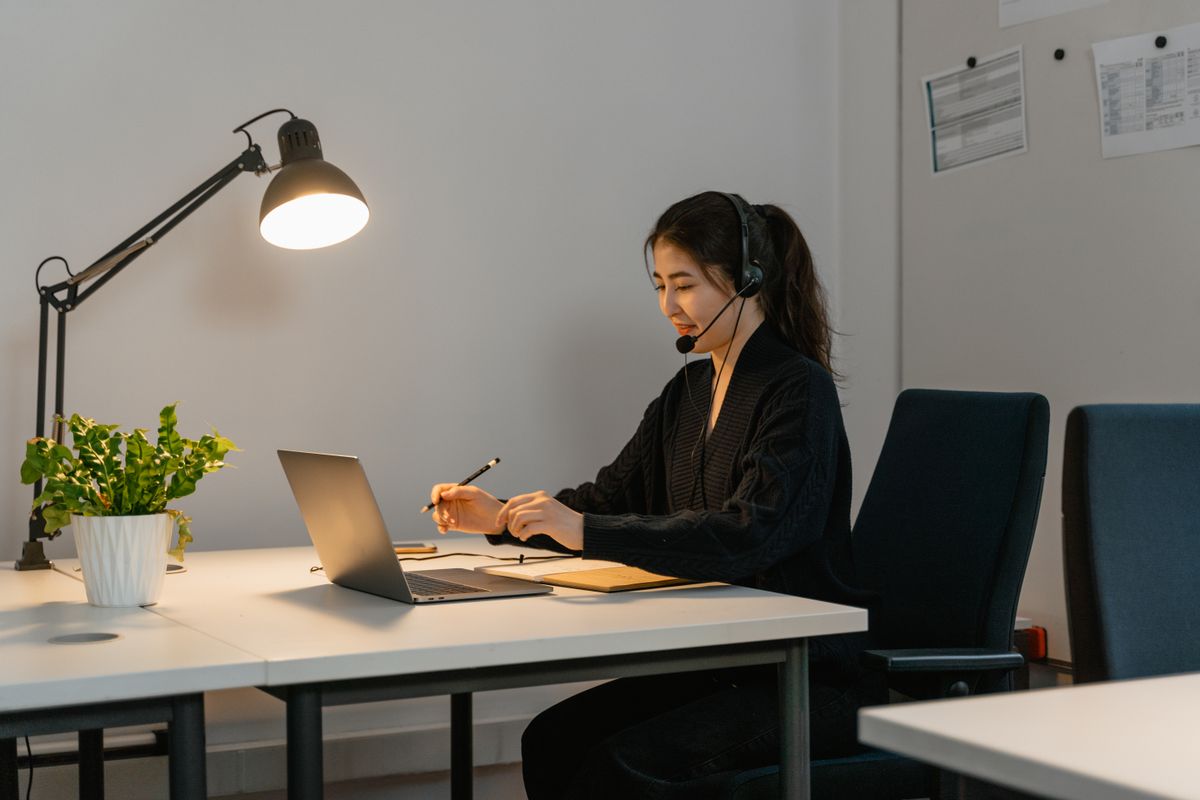 Customer support professional using a laptop and headset