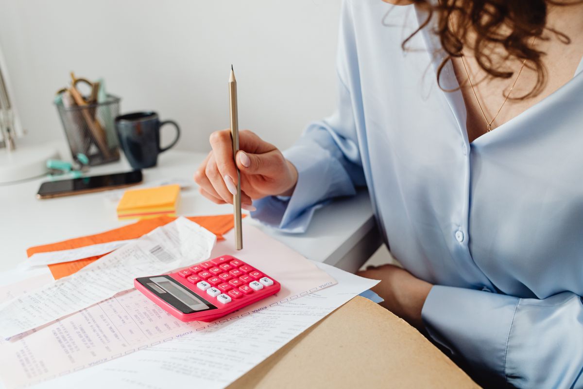 Woman working through household paperwork with a pencil